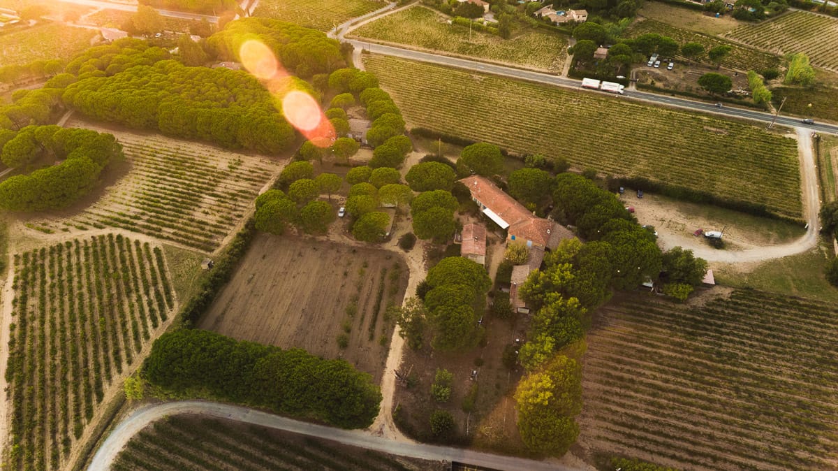 Vue aérienne de la Ferme de l'Empereur et de ses vignobles au coucher du soleil.