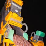 Machine à vendanger déversant des raisins fraîchement récoltés de nuit.
